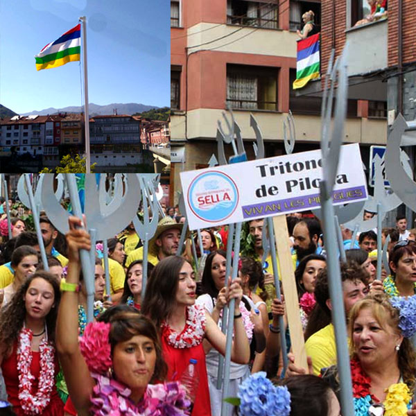 Desfile de la Fiesta de las Piraguas y bandera del Sella ondeando en Arrionda