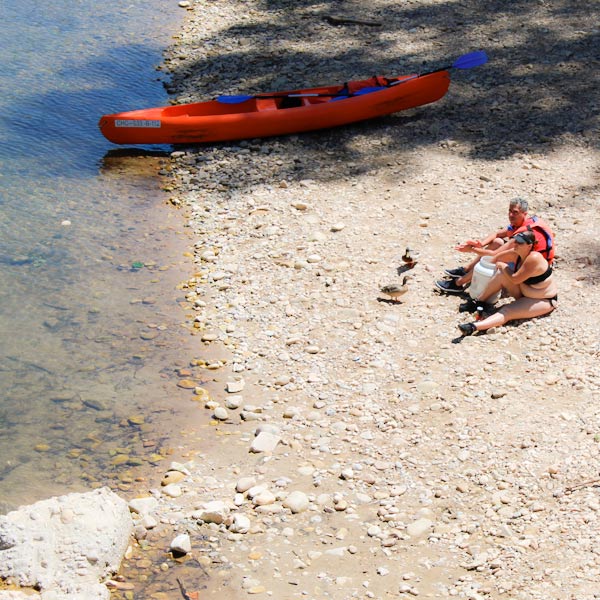 Gente descansando a la orilla del río Sella