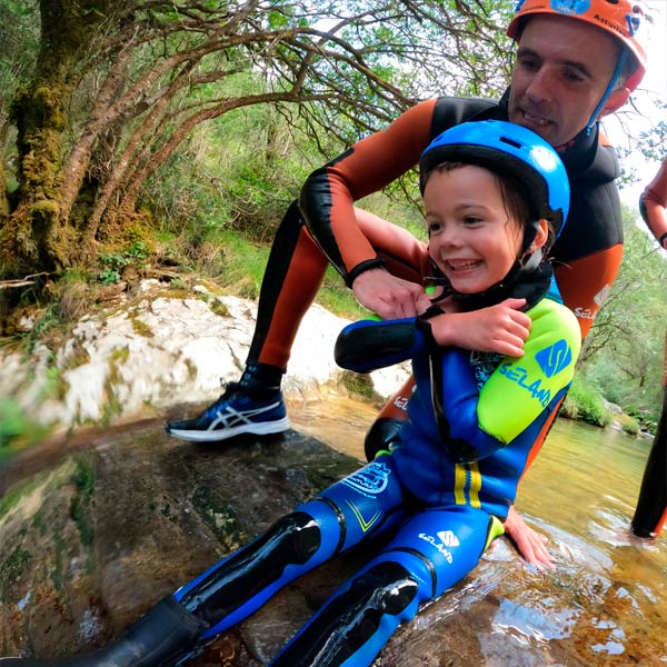 Niño lanzándose por tobogán en descenso de barrancos nivel básico