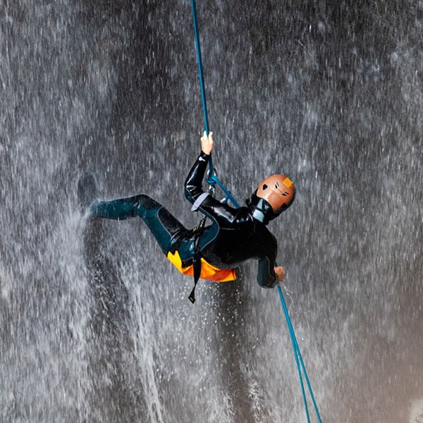 hombre descendiendo barranco con cuerda en descenso de barrancos extremo