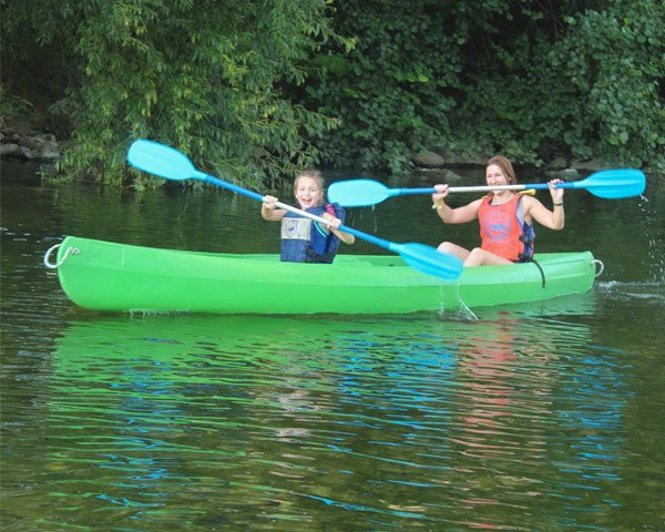 Madre con niña surcando el río Sella a bordo de una canoa de Aipol Aventura