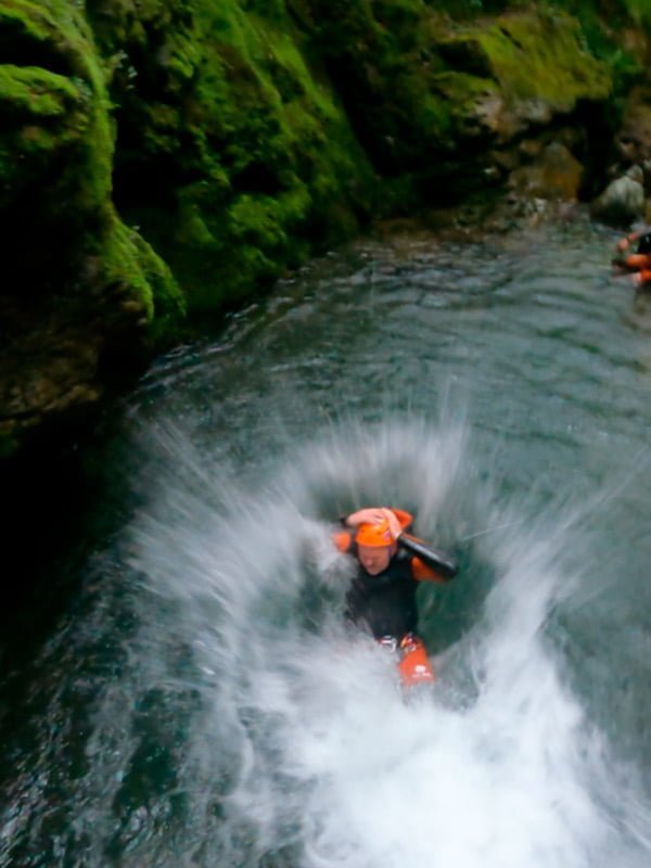Persona haciendo descenso de cañones entrando en el agua