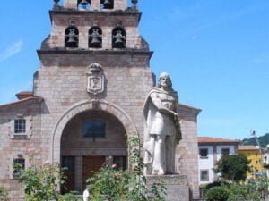 La estatua de Don Pelahyo con la Iglesia de la Asunción detrás