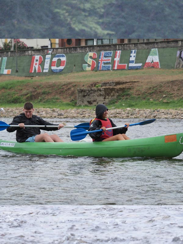 Pareja en canoa en Arriondas haciendo el descenso del Sella lloviendo