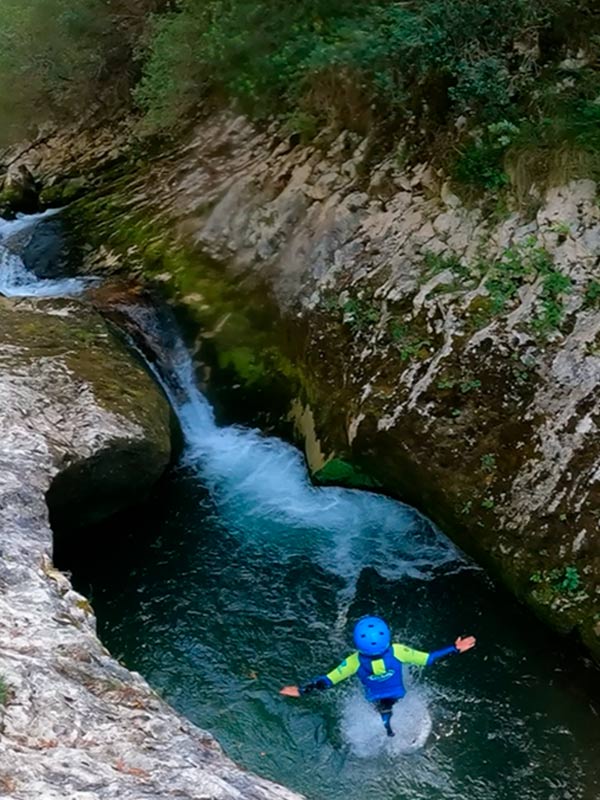 Niño haciendo descenso de barrancos en el río del barranco Rubó