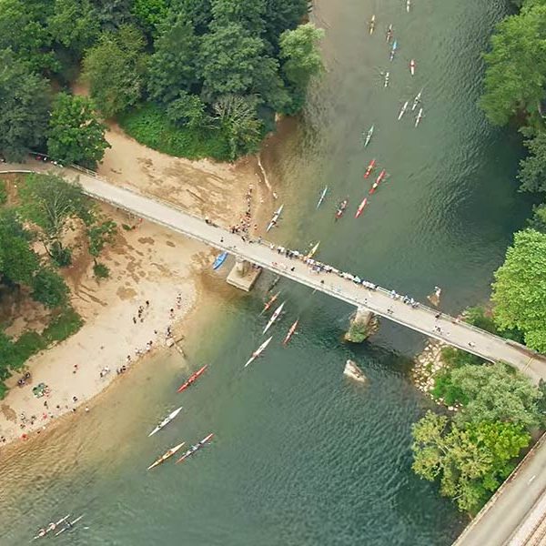 Las canoas durante la competición pasando por el Puente de Toraño
